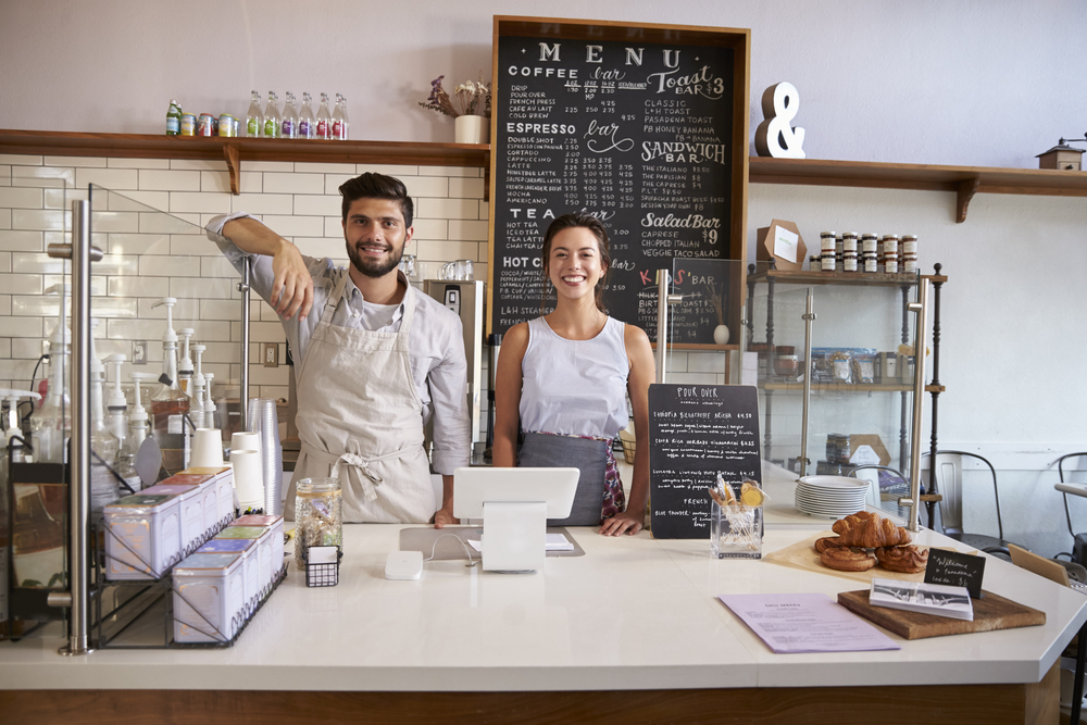 Couple standing in front of organic food store smiling Business Insurance in Massachusetts